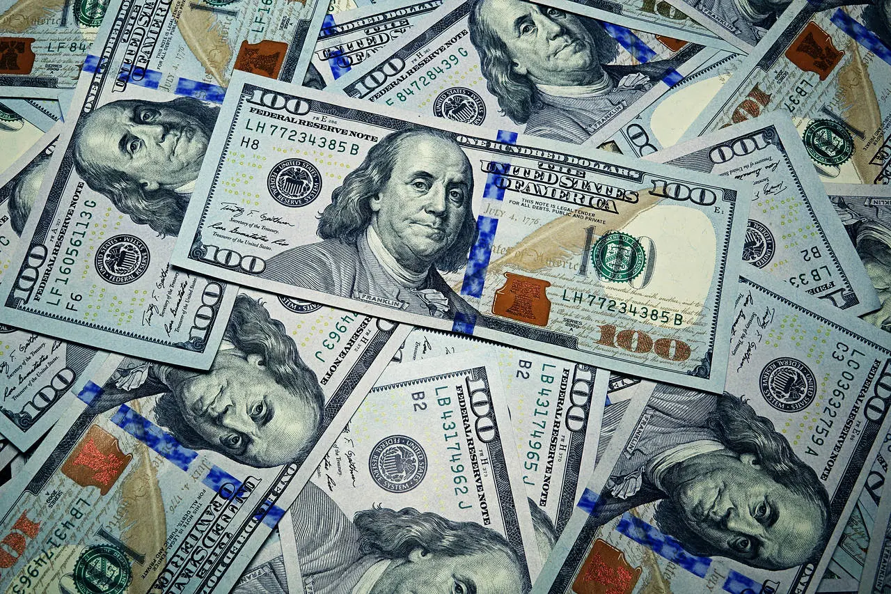 Pile of hundred-dollar bills scattered around.