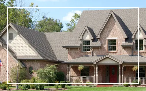Brick house with gabled roof and porch.