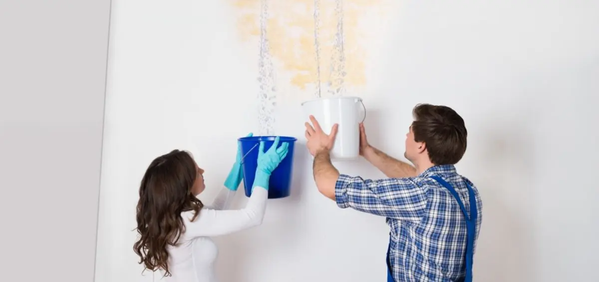 People collecting water from ceiling leak.